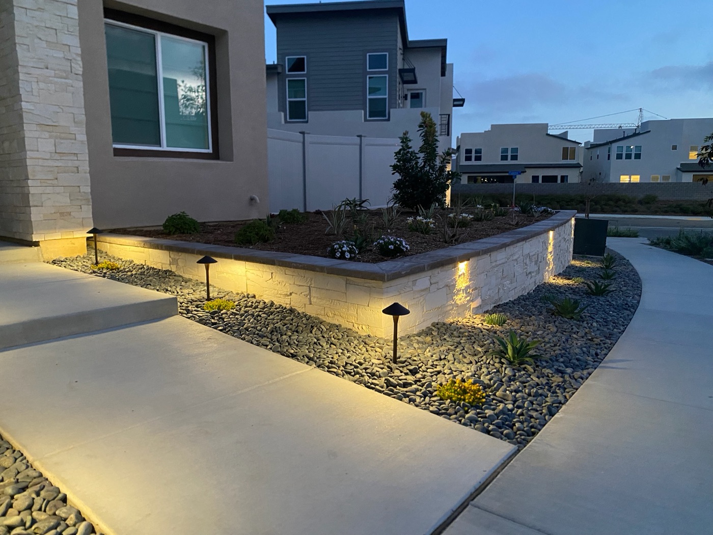 Front-yard planter wall with landscape lighting in Scott by Abshire Brothers Lawn & Landscape