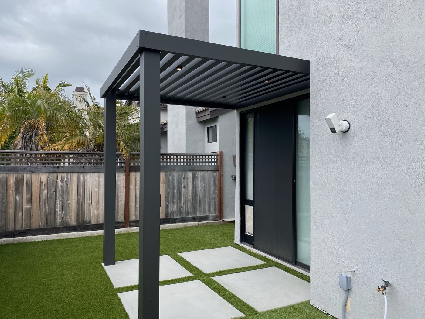 Louvered pergola over turf and pavers in Carencro by Abshire Brothers Lawn & Landscape