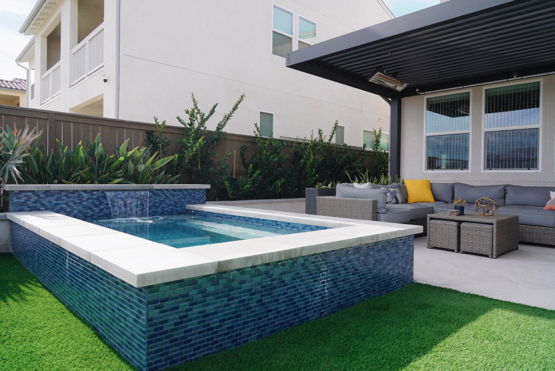Blue-tile spa and pool with a louvered pergola, designed and built by Abshire Brothers Lawn & Landscape in Eunice, Acadiana