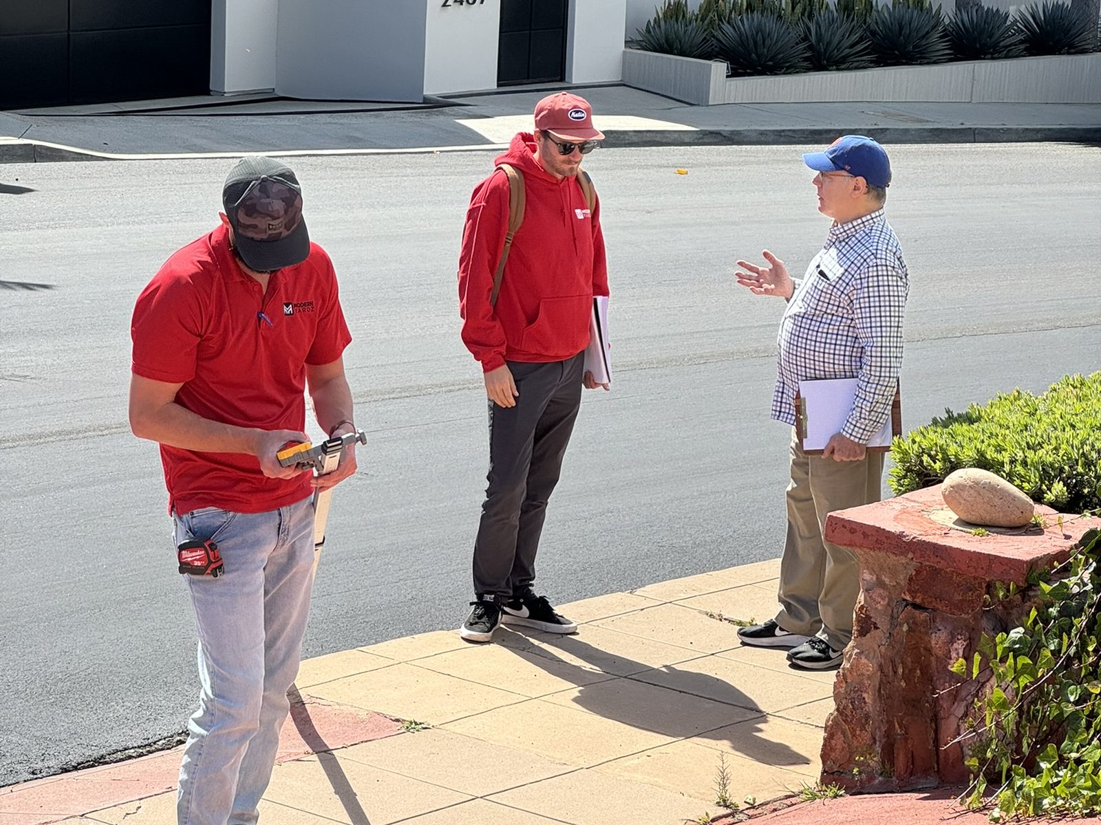 Abshire Brothers Lawn & Landscape team measuring a Rayne property with the homeowner during a free design consultation