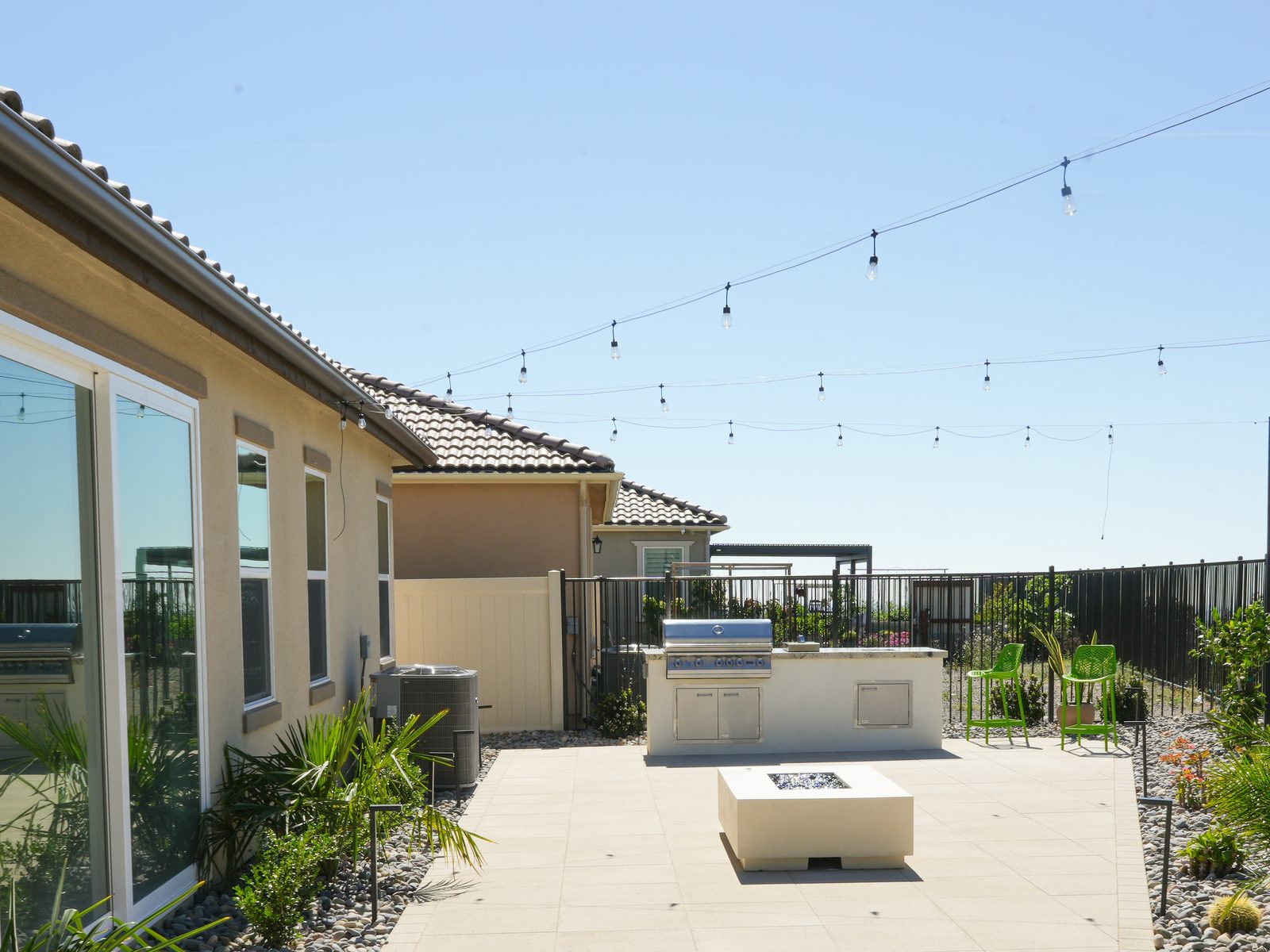 Backyard with outdoor kitchen, fire table and paver patio by Abshire Brothers Lawn & Landscape Rayne